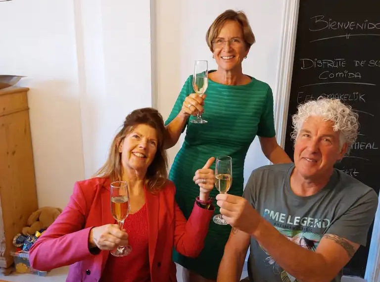 Tevreden klanten met een glas in de hand bij Todo Cambia